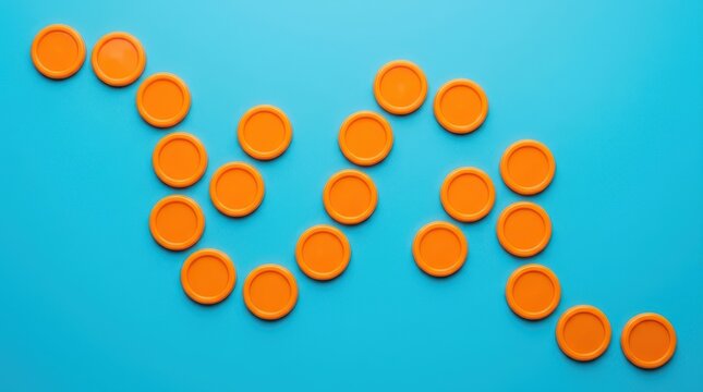 Top view of orange plastic game tokens arranged in a wavy pattern on a vibrant blue background
