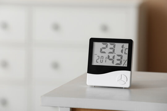Indoor climate control and home comfort, digital hygrometer and thermometer measuring room temperature and humidity levels on a bedside table