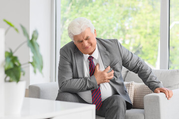 Heart attack and chest pain, senior businessman suffering from sudden cardiac arrest or angina...