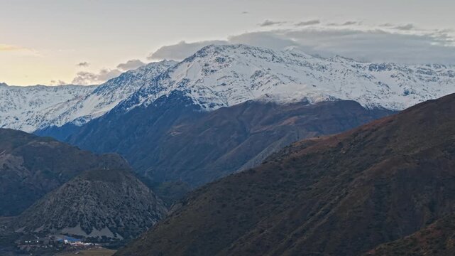 A telephoto aerial view of the Caj&oacute;n del Maipo mountains on a clear morning, with snow-capped peaks