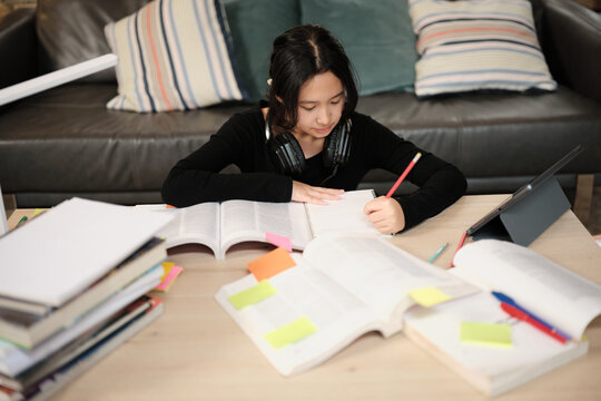 One Asian teenage girl concentrates on learning at home, reading textbooks, note writing, self-tutorial exams, preparation for back to school, Homeschooling, university knowledge education lifestyle.