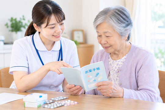 看護師と高齢者がお薬手帳を確認