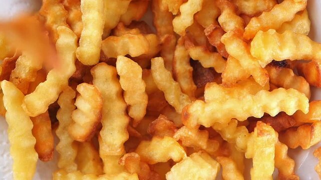 Enjoying crispy crinkle cut fries at a food stall