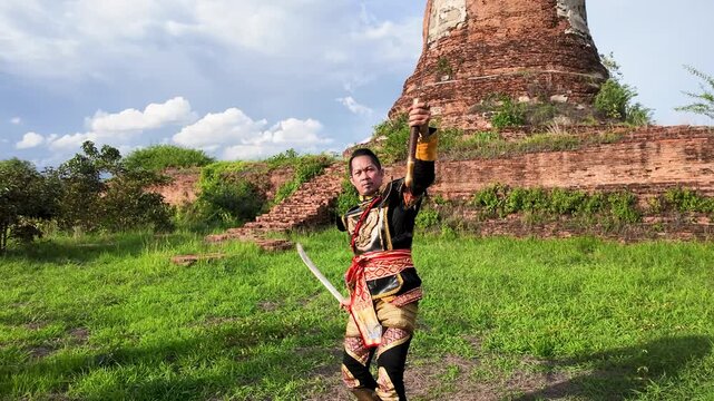 Thai Warrior in Traditional Armor Holding Swords at Ayutthaya Ruins