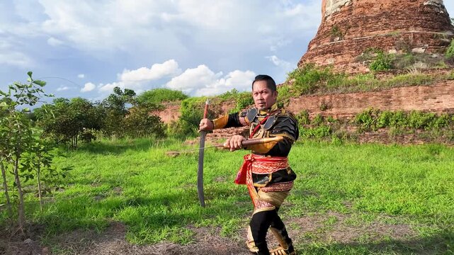 Thai Warrior in Ancient Armor Training with Swords at Ayutthaya Ruins