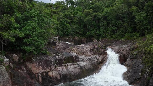 Low Aerial Drone Flight Along a Wild Mountain Stream in Chu Yang Sin National Park, Dak Lak, Vietnam, Revealing a 3-Meter Waterfall Surrounded by Rocky Cascades and Dense Forest