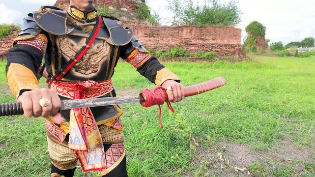 Thai Warrior in Ancient Armor Drawing Sword at Ayutthaya Ruins