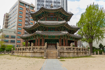 Obraz premium Traditional Korean historic pavilion contrasted with modern urban architecture