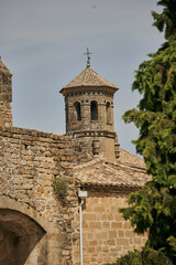 Obraz premium Octagonal bell tower of the historic University Chapel with glazed ceramic discs, tiled roof and stone architecture in Baeza, Andalusia, Spain