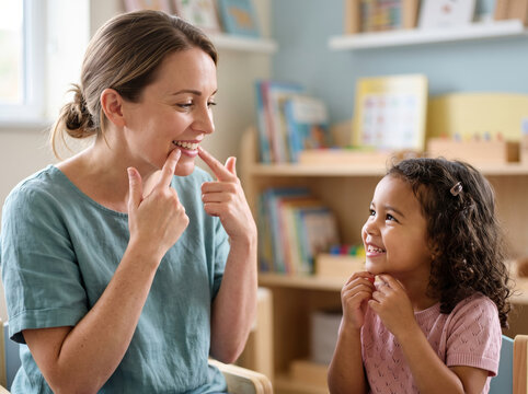 Speech Language Pathologist Working With Little Girl In Therapy Room