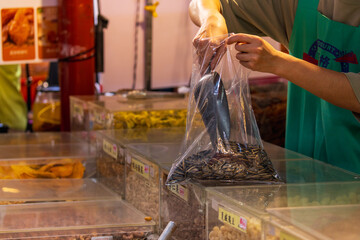 Obraz premium Vendor Bags Sunflower Seeds at Dihua Street Market