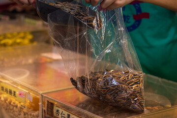 Obraz premium Vendor Bags Sunflower Seeds at Dihua Street Market