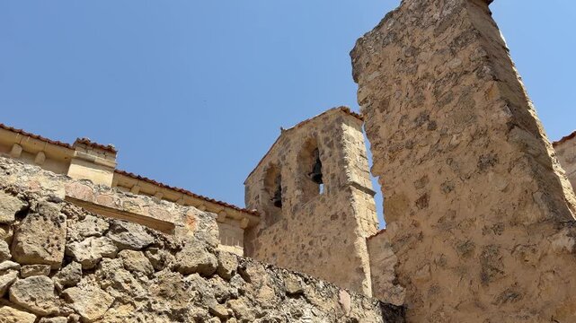 Medieval stone bell tower ruins against blue sky
