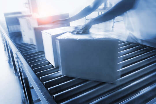 Workers Moving Package Boxes on Conveyor Belt. Distribution Warehouse Shipping. Package Boxes Supplies. Supply Chain Shipment Goods. Distribution Warehouse. Logistics