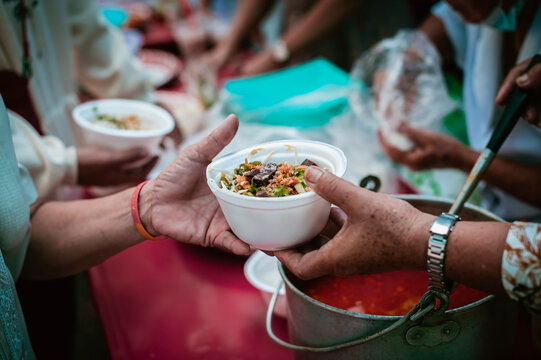 hands of the poor receive food from the donor's share , Feeding the poor to help and share