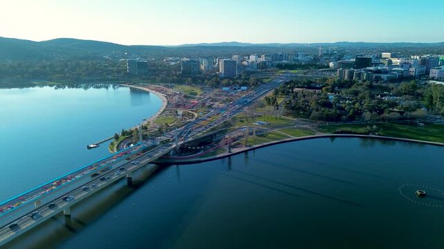 Drone aerial landscape of car and vehicle traffic driving along the Commonwealth Avenue Bridge with the scenic waterfront at Lake Burley Griffin in Parkes Canberra ACT Australia tourism infrastructure