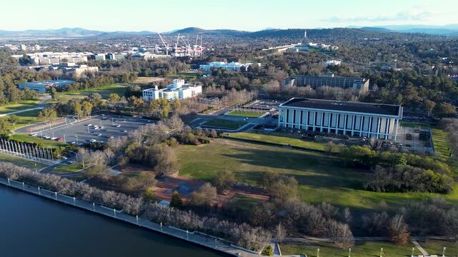 Drone aerial landscape of the National Library of Australia with the scenic waterfront at Lake Burley Griffin and Parliament House in the background capital city of Canberra ACT tourism infrastructure