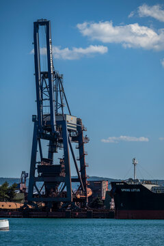 Koper, Slovenia - August 8, 2026: Bulk carrier ship Spring Lotus docked next to a large industrial crane at the Port of Koper (Luka Koper).