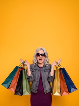 Excited Senior Woman with Sunglasses Holding Colorful Shopping Bags