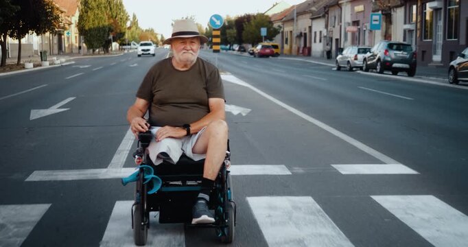 Elderly man in an electric wheelchair drives through city traffic, signals, changes lane and turns, showing independent mobility and confident everyday transportation.