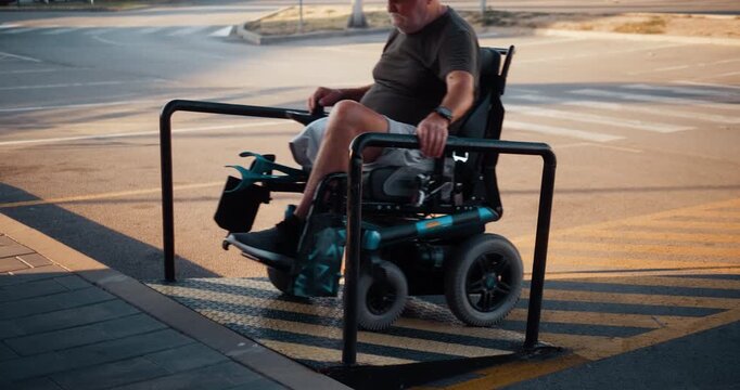 Senior man in an electric wheelchair ascends an accessible ramp in the city, showing independent mobility and inclusive urban infrastructure for people with disabilities.