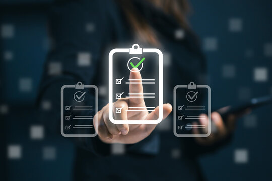 Business professional selecting a digital checklist with check marks on virtual interface, representing task completion, quality control, audit, compliance and efficient workflow management.