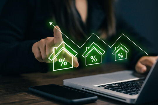Businesswoman analyzing home interest rates on a laptop with digital house percentage icons and growth chart, illustrating mortgage finance, property investment and real estate trends.