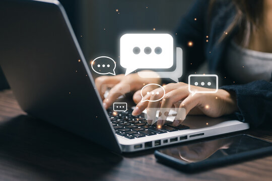 Businesswoman typing on laptop with floating chat message icons, illustrating online communication, customer support, messaging, social networking, remote work and digital collaboration.