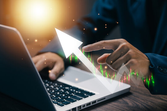 Business professional analyzing stock market growth on laptop with candlestick chart and rising arrow, illustrating investment strategy, financial success, trading and business performance.