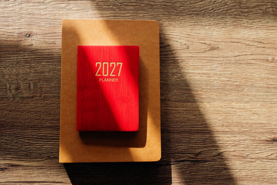 Red 2027 planner notebook on wooden background