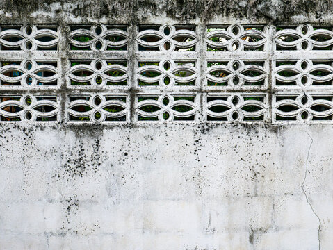 Ornate Concrete Breeze Block Wall with Floral Pattern and Mold Stains