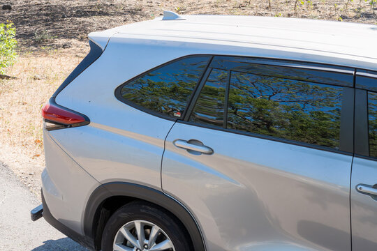A close-up view of the rear side of a modern silver car parked outdoors under natural.
