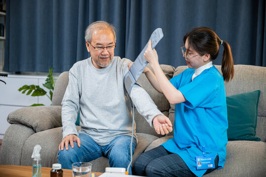 Asian doctor woman examine do checking old man client heart rate with pulsimeter monitor