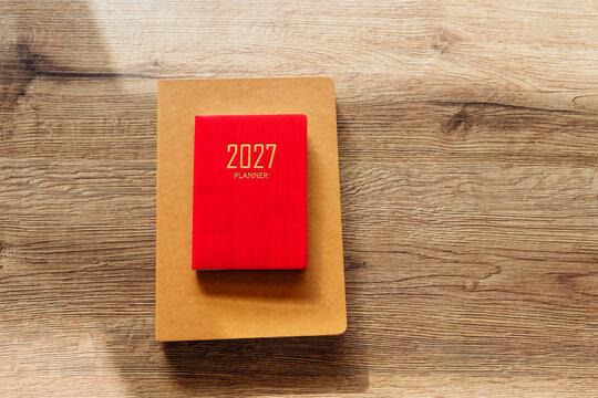 Red 2027 planner notebook on wooden background