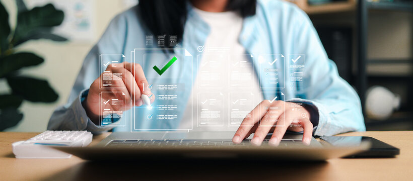 Reviewing digital documents and approval checklists on a laptop with holographic interfaces, representing workflow management, compliance,