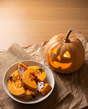 Tactile Macro Flat Lay Detail: Carved Pumpkin Face, Paper Ghosts, and Pumpkin Slices