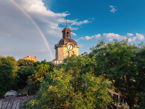 Historic clock tower of Varna with bright rainbow in blue sky after rain in Bulgaria