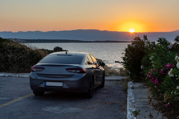 Obraz premium Gray sedan parked at scenic coastal sunset overlook