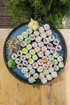 Large assorted sushi maki platter on a wooden table