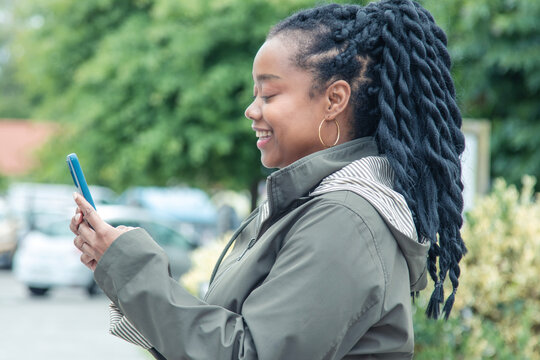 black woman with phone on the street