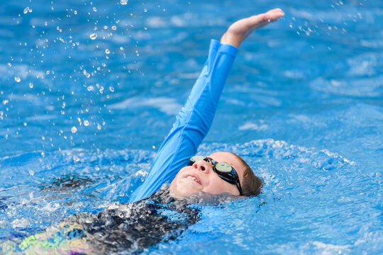 Portrait of a young swimmer while swimming on his back