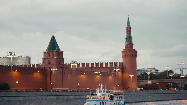 Tourist boat sailing on moskva river by the kremlin wall