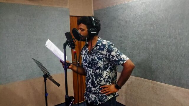 Heavy noise grain video of Male voice artist reading script for film dubbing on recording studio at hyderabad, telangana, india. internal shot, hand held shot, 4k.