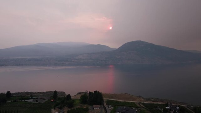 Smoke above small Canadian city in the mountains by a lake