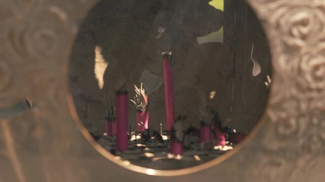 Ornate Circular Opening Reveals A Vessel Filled With Ash And Burning Red Incense Sticks. - closeup shot