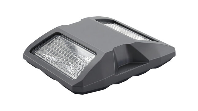 Gray solar powered road stud with reflective clear lenses for highway illumination.