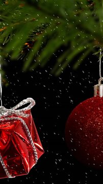 Animation of red christmas baubles decoration with snow falling