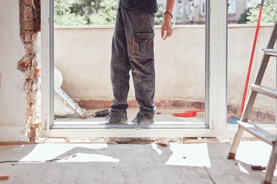 Workers changing old windows and doors in the apartment.