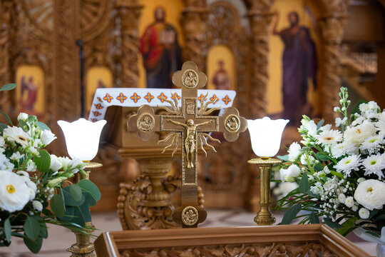 Golden altar cross with rays and floral background