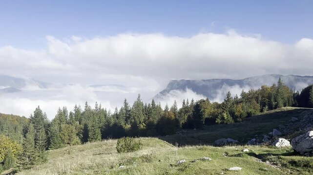 Handheld pan left over spectacular mountain cloud inversion valley landscape at Mount Maglic Bosnia
